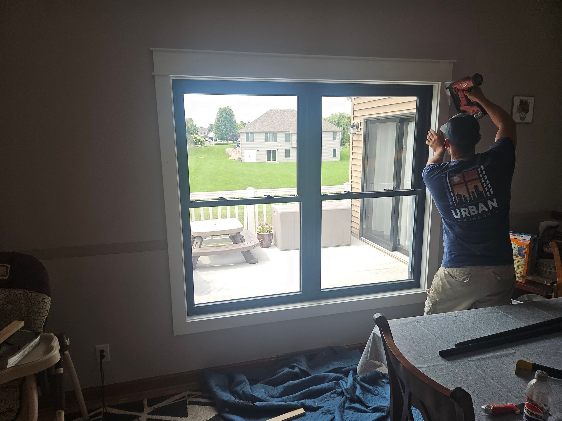 A man is installing a window in a living room.