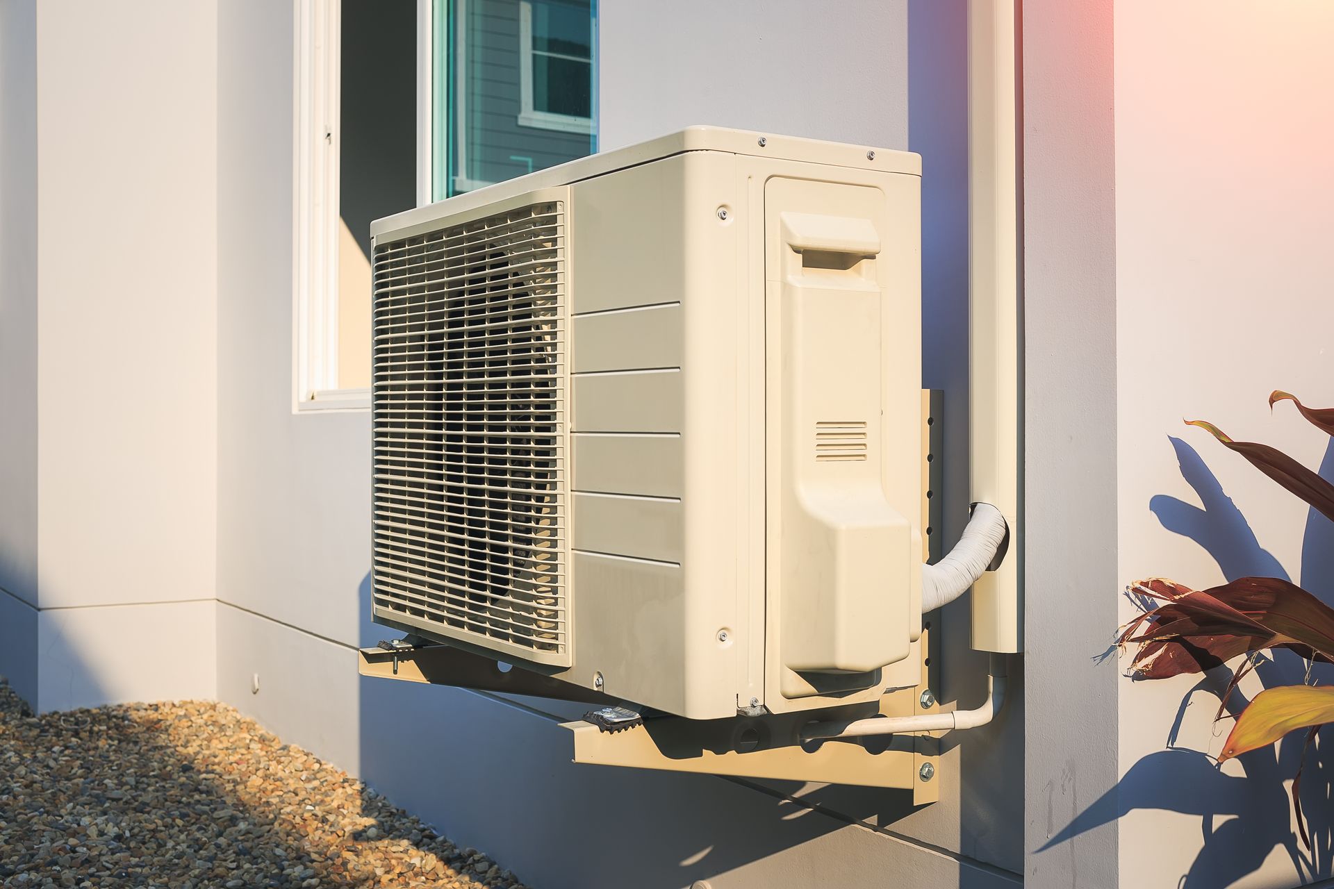 Un climatiseur blanc est monté sur le côté d'un bâtiment.