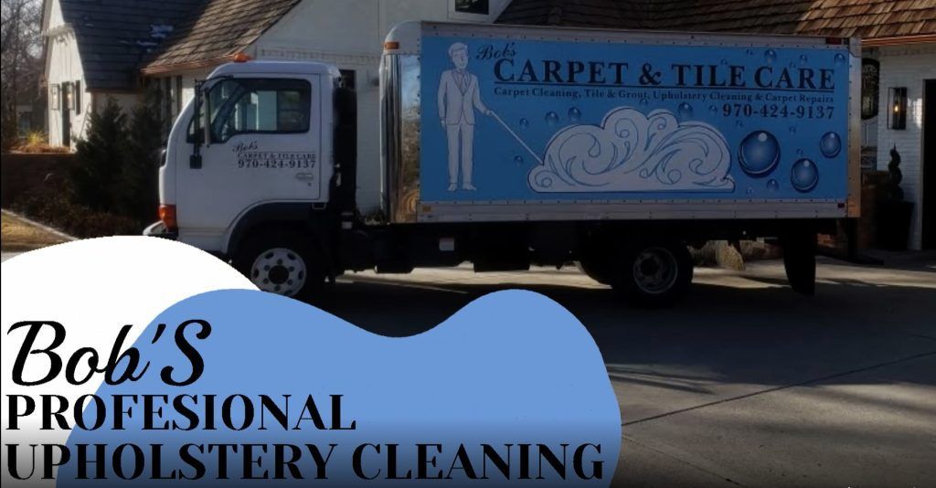 A bob 's professional upholstery cleaning truck is parked in front of a house.