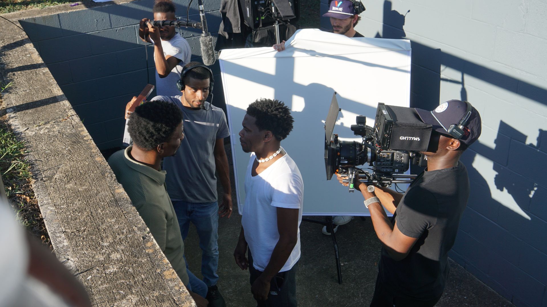 A group of men are standing in front of a camera.
