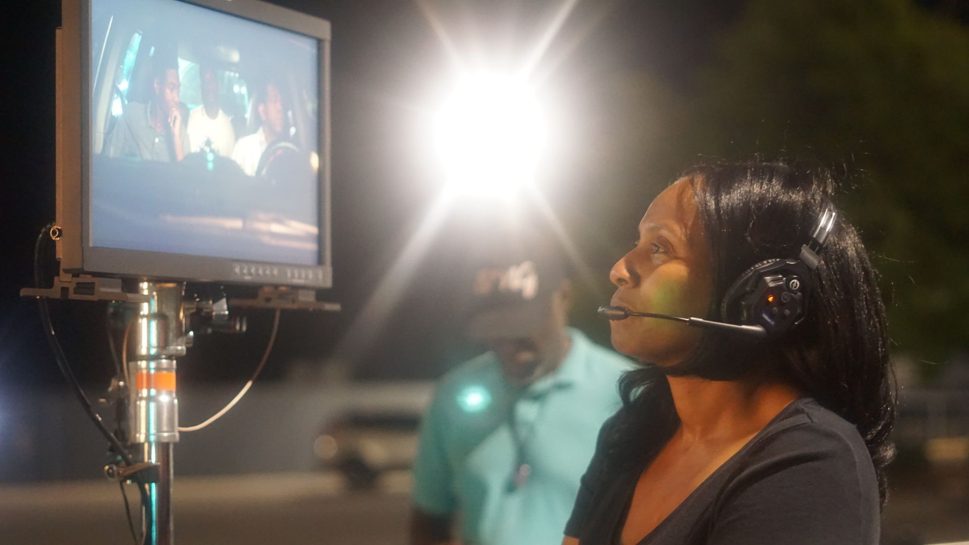 A woman wearing headphones is looking at a computer screen.