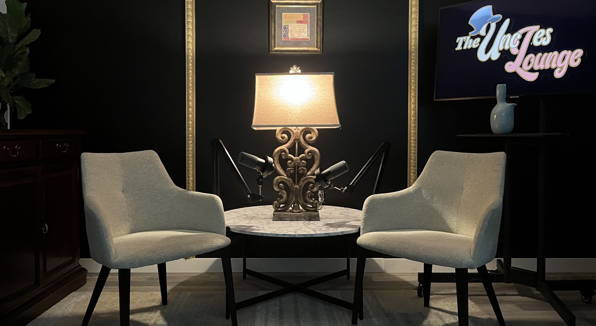 Two chairs are sitting in front of a table with a lamp and a sign that says the ulysses lounge