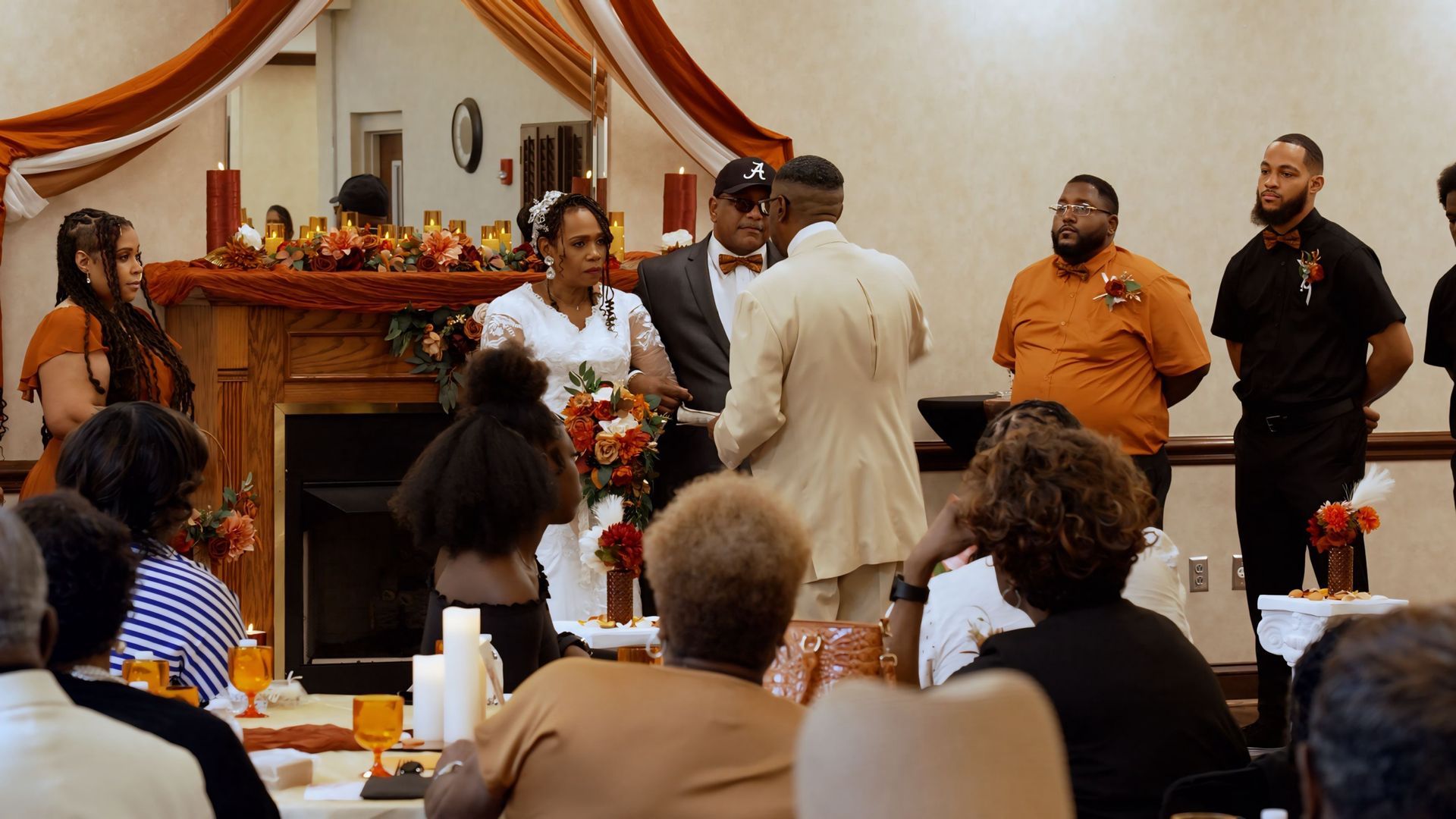 A bride and groom are getting married in front of a crowd of people.
