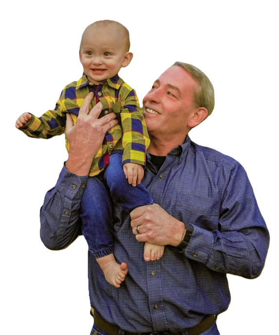 A man is holding a baby on his shoulders