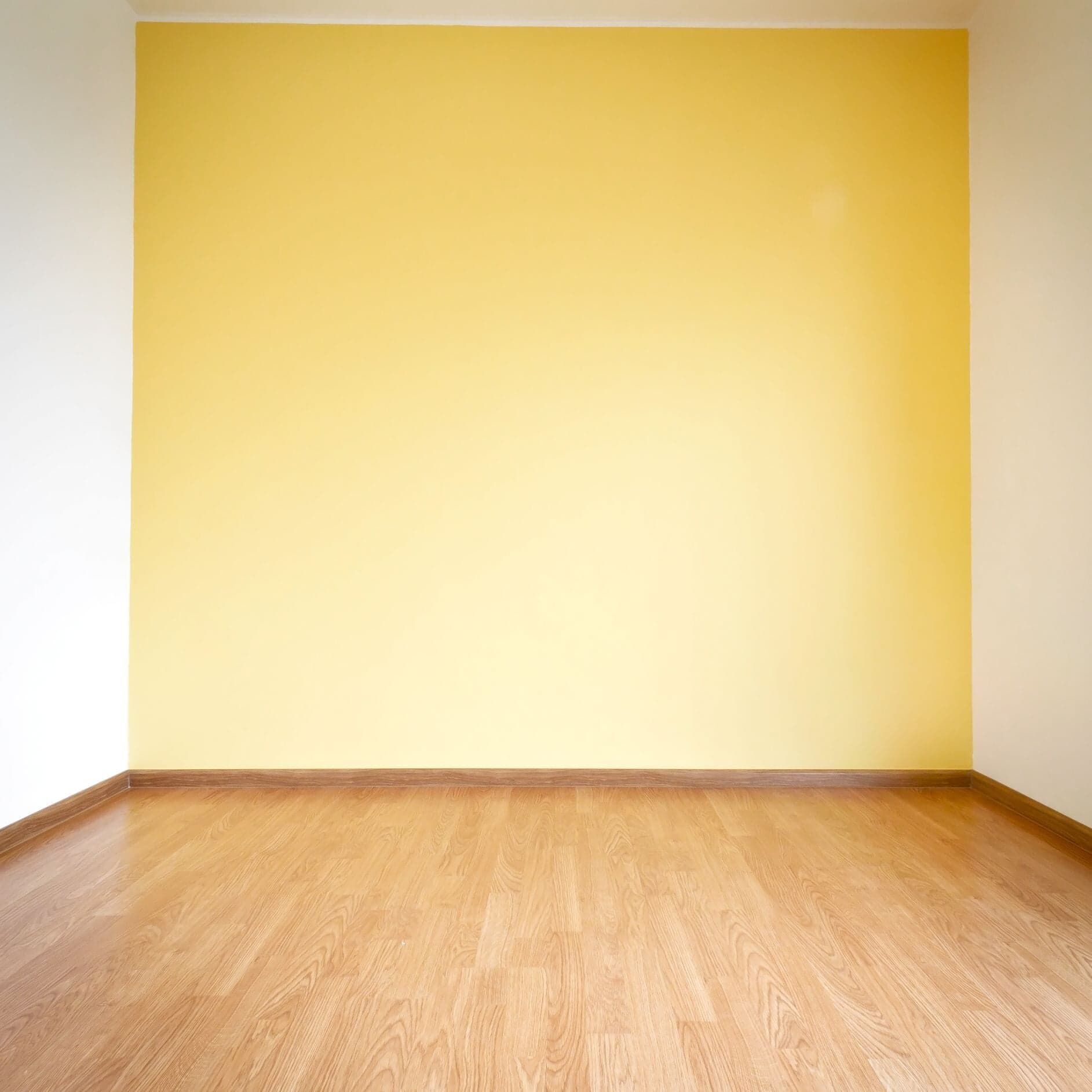 Wall With Yellow Paint Wooden Textured Flooring — Painters in Mackay
