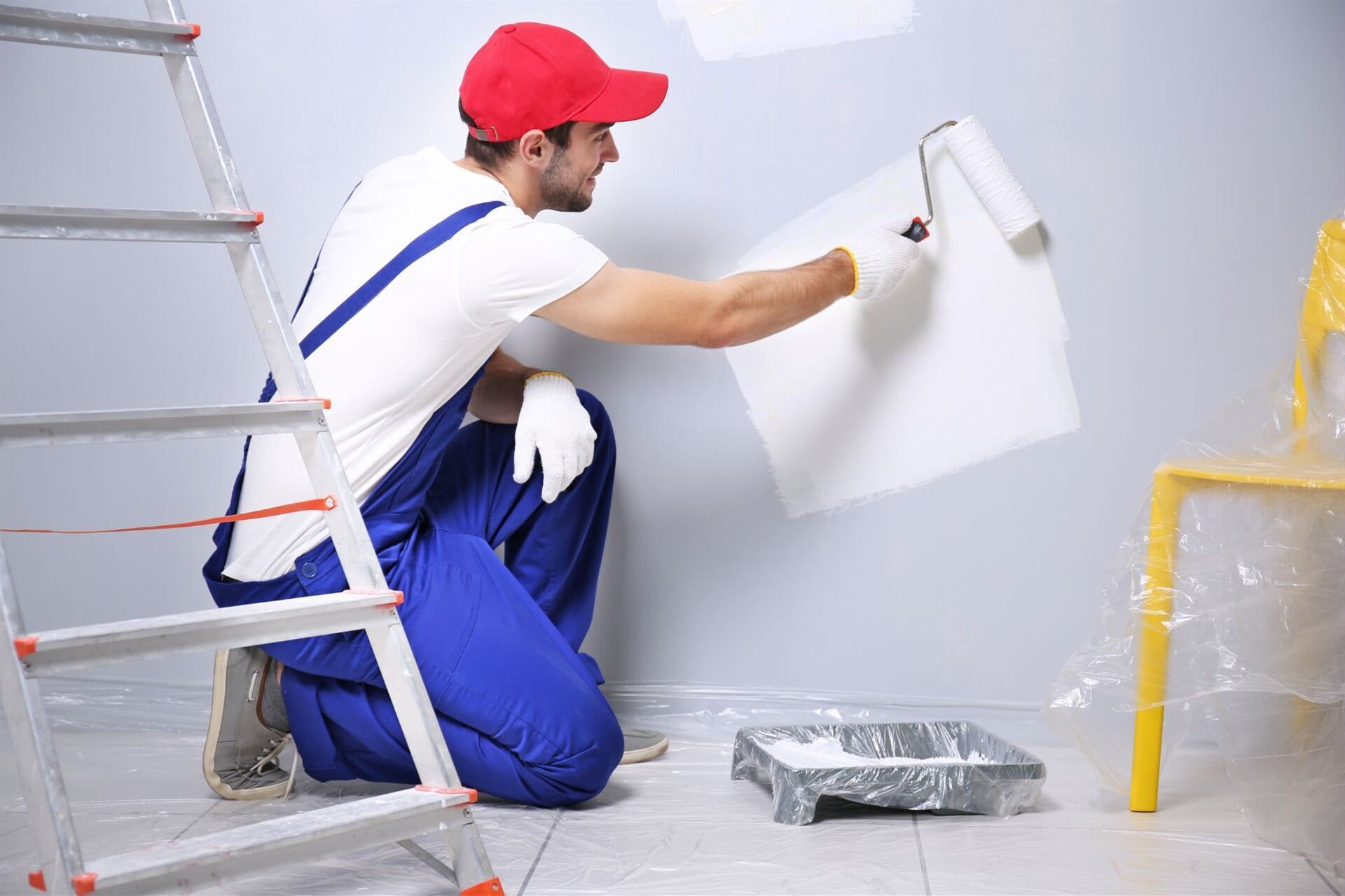 Man Wearing a Red Cap Painting The Wall — Painters in Mackay