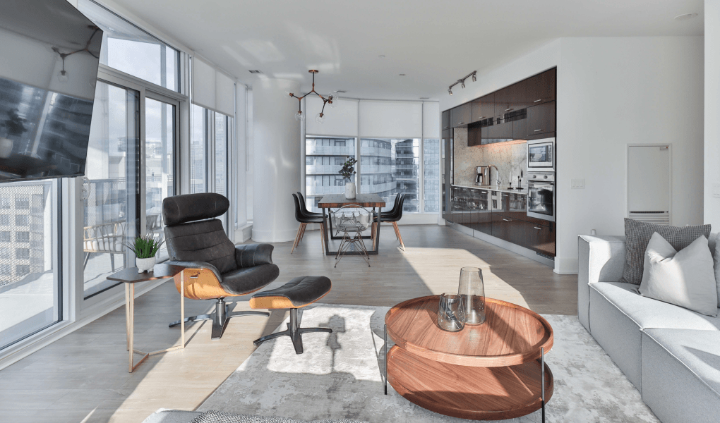A living room with a couch , chair , coffee table and television.