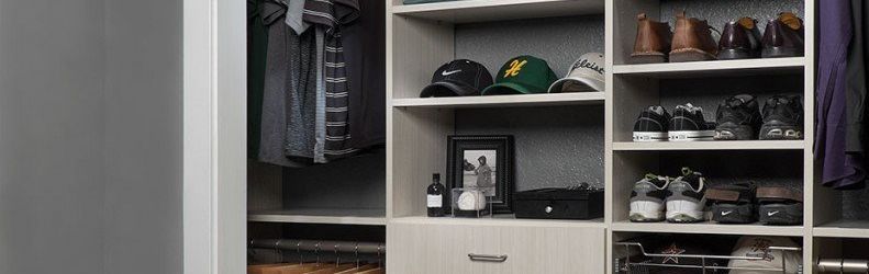 A closet filled with clothes , shoes , hats and a picture.