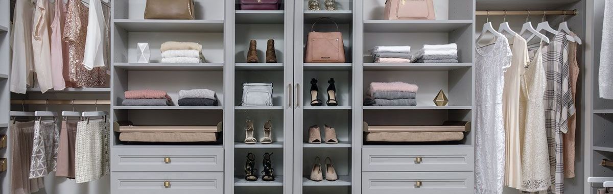 A walk in closet filled with lots of clothes and shoes.