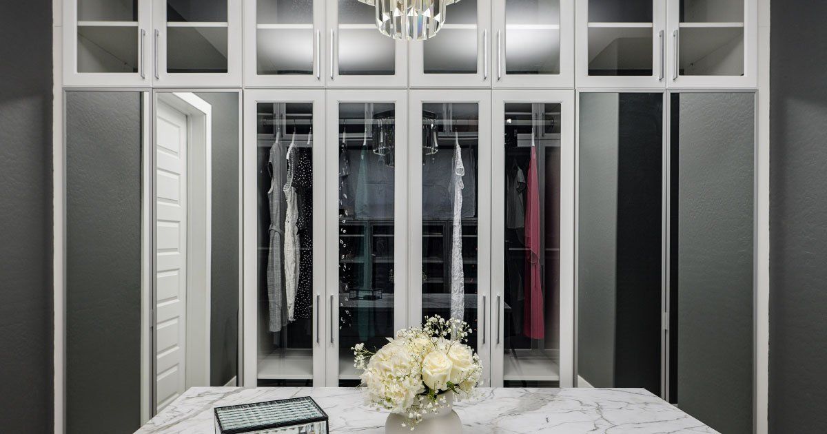 There is a vase of flowers on the table in the closet.