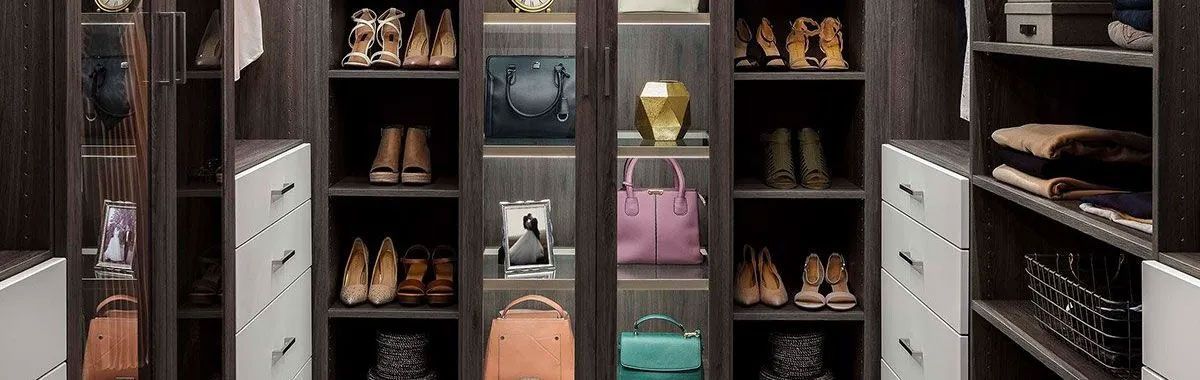 A walk in closet filled with lots of shoes and handbags.