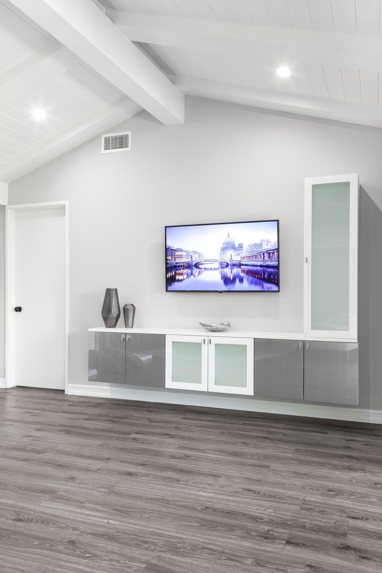 A living room with a flat screen tv on the wall.