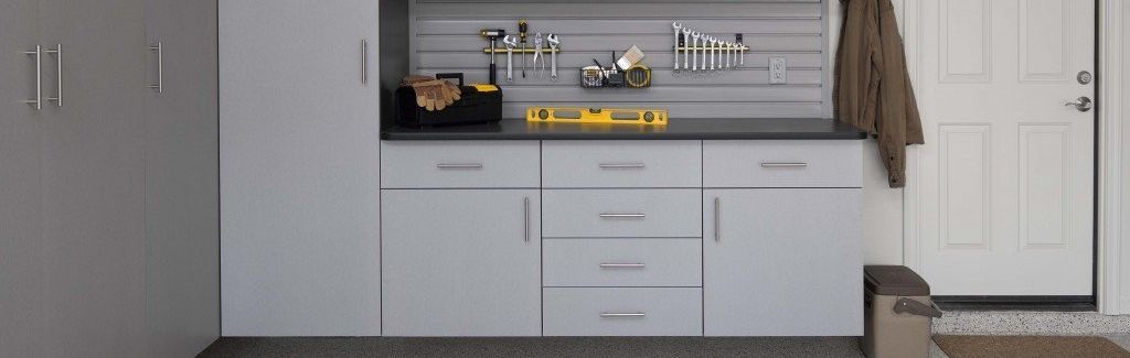 Garage storage system with tools, cabinets, and a door.