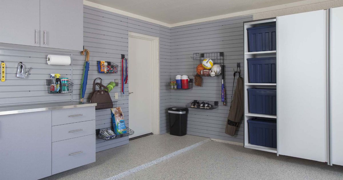 Garage interior with gray cabinets, wall storage, and a white door.