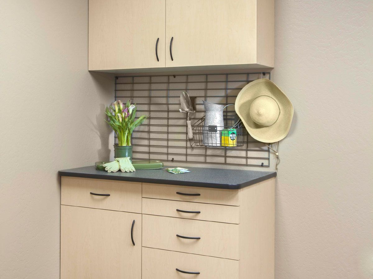 A kitchen with wooden cabinets and a hat hanging on the wall