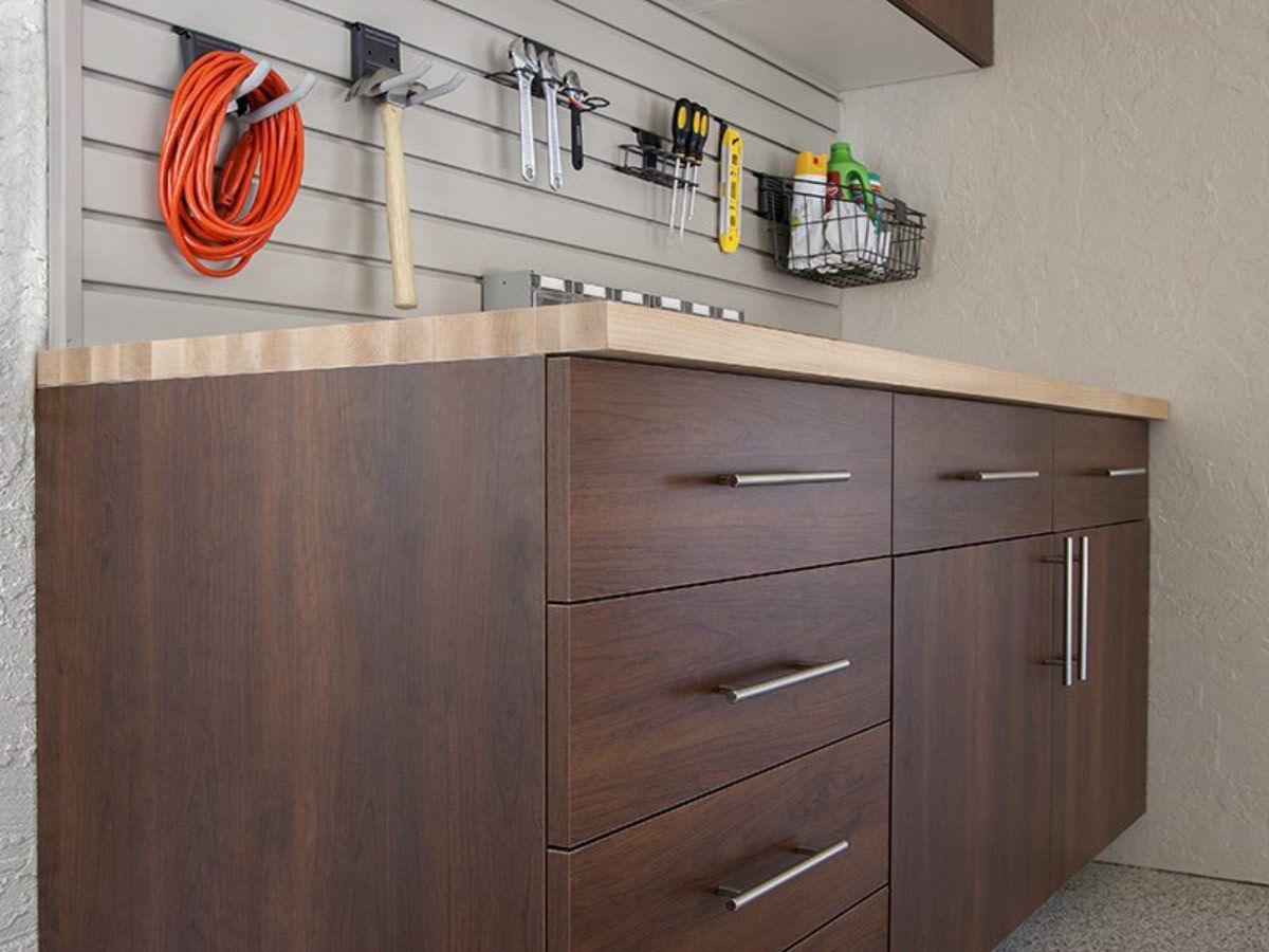 A wooden cabinet with drawers and a wooden counter top in a garage.