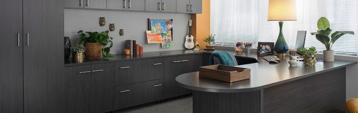 A home office with gray cabinets and a desk