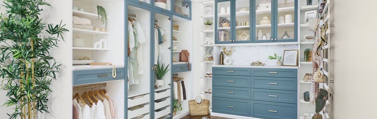 A walk in closet with blue cabinets and white shelves.