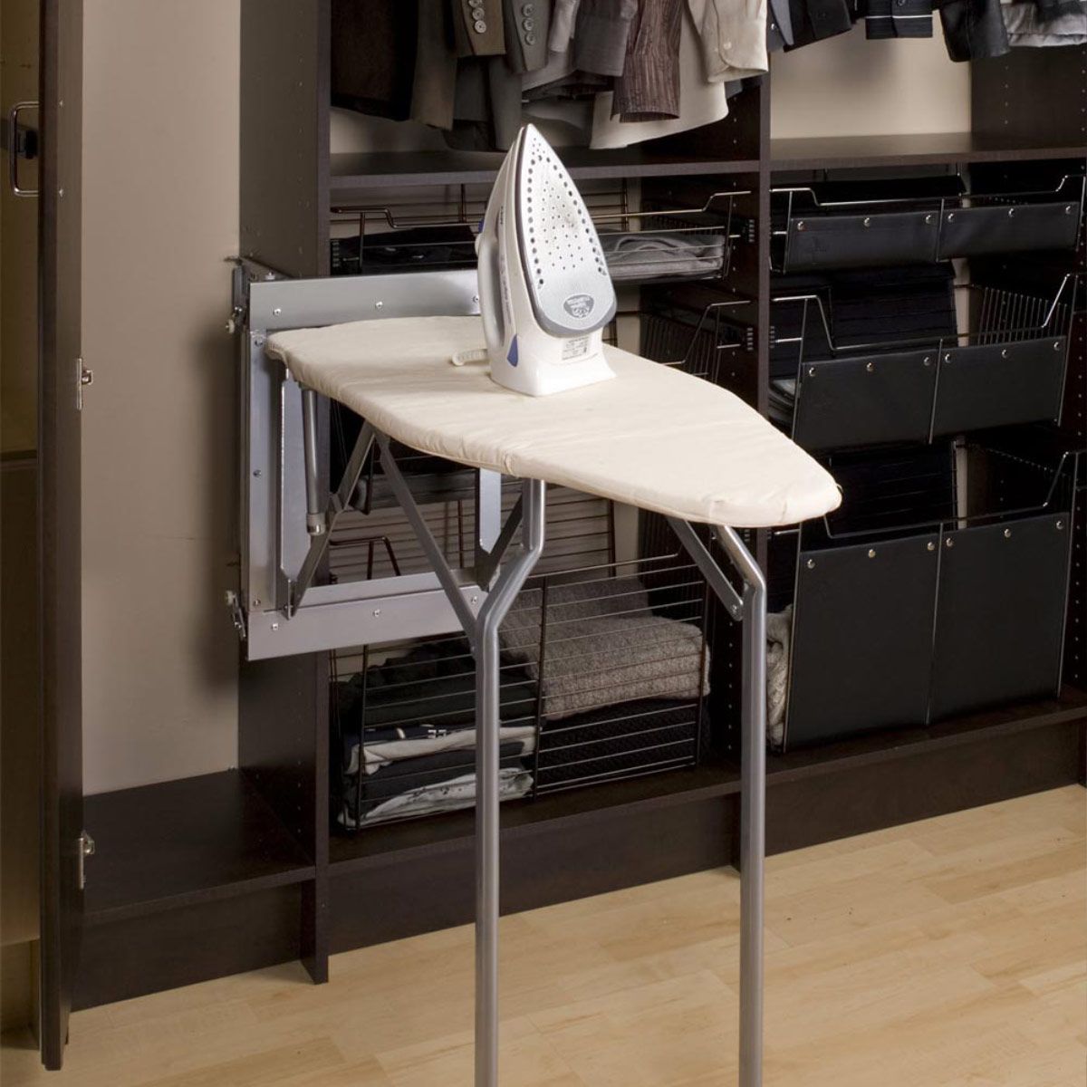 An iron is sitting on top of an ironing board in a closet.