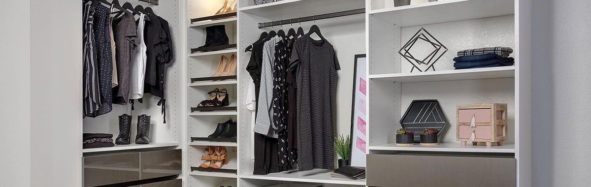 A walk in closet filled with clothes and shoes and a mirror.