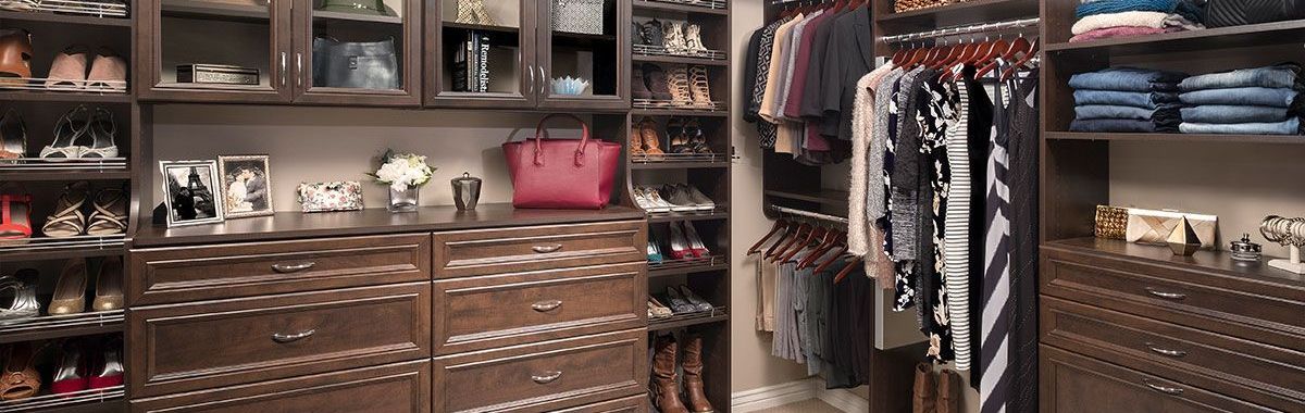 A walk in closet filled with lots of clothes and shoes.