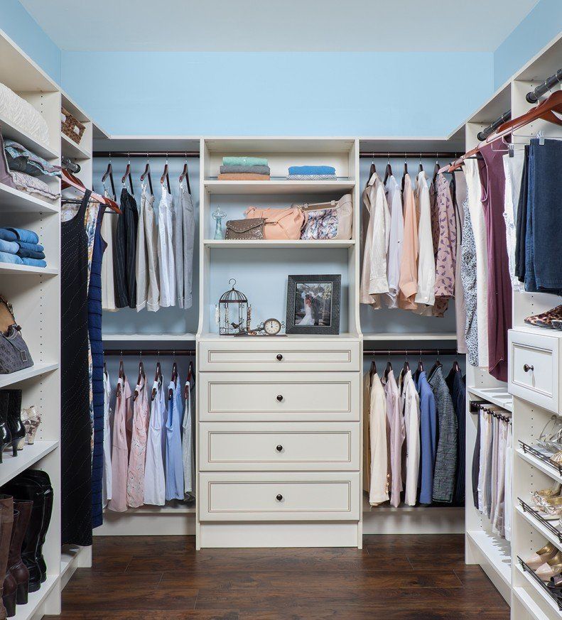 A walk in closet filled with clothes and a dresser