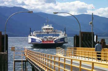 A ferry is docked at a pier in the water.