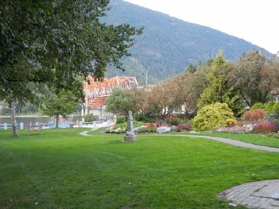 A park with a house in the background and mountains in the background.