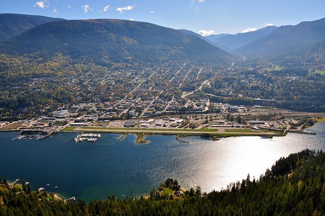 An aerial view of a city surrounded by mountains and a lake.