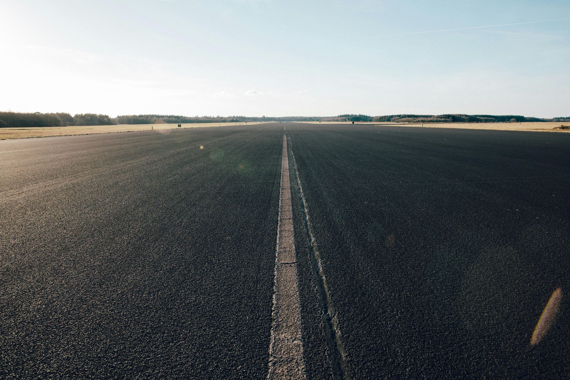 An empty runway with a white line on the side of it.