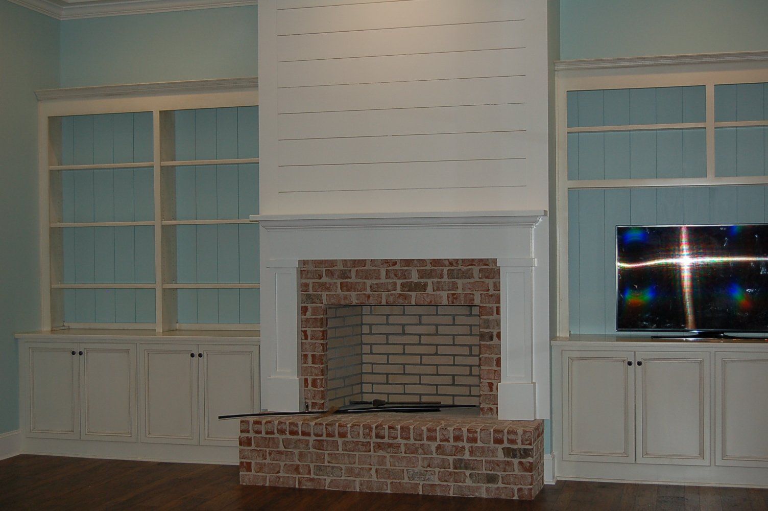 A living room with a fireplace and a flat screen tv