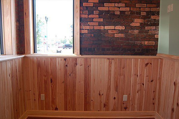 A room with wood paneling and a brick wall.