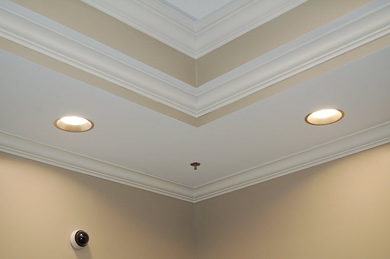 A ceiling with two lights on it and a camera on the wall.