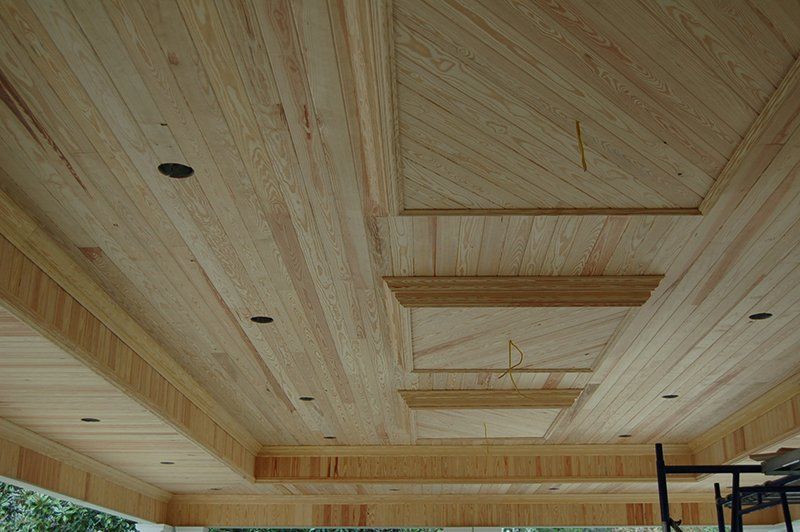 A wooden ceiling with a scaffolding in the background.