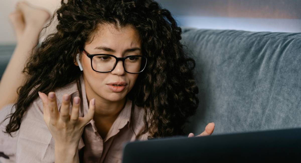 A woman looking at her laptop confused and frustrated