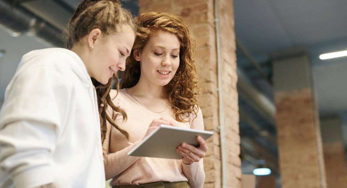 Two colleagues tracking data on an iPad