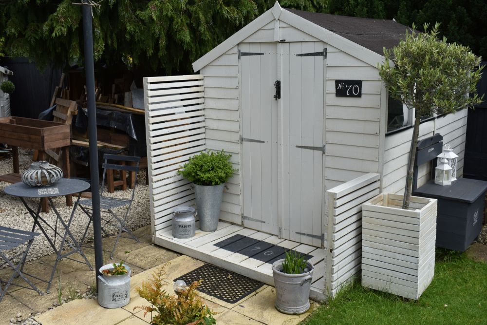 White Shed With Slatted Side Panels, Potted Plants — JNR Building And Maintenance in Green Hill, QLD