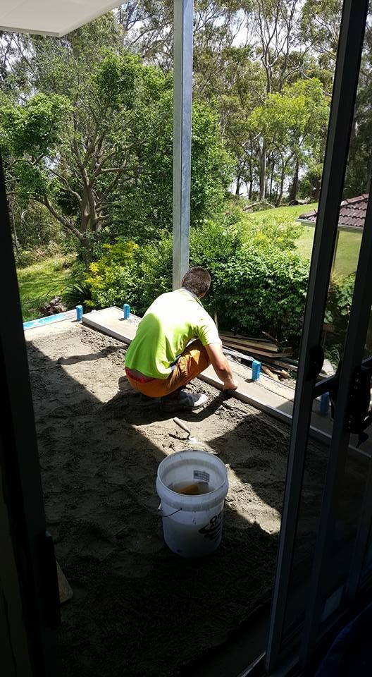 Man Leveling Sand on a Patio, Using a Level — JNR Building And Maintenance in Green Hill, QLD
