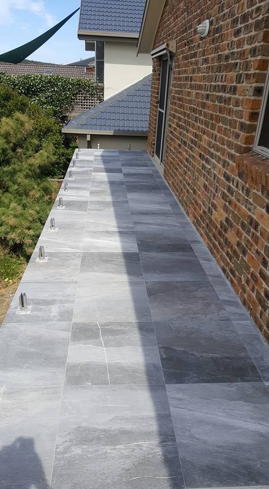 Exterior View of a Narrow Tiled Walkway Alongside a Brick Building — JNR Building And Maintenance in Green Hill, QLD