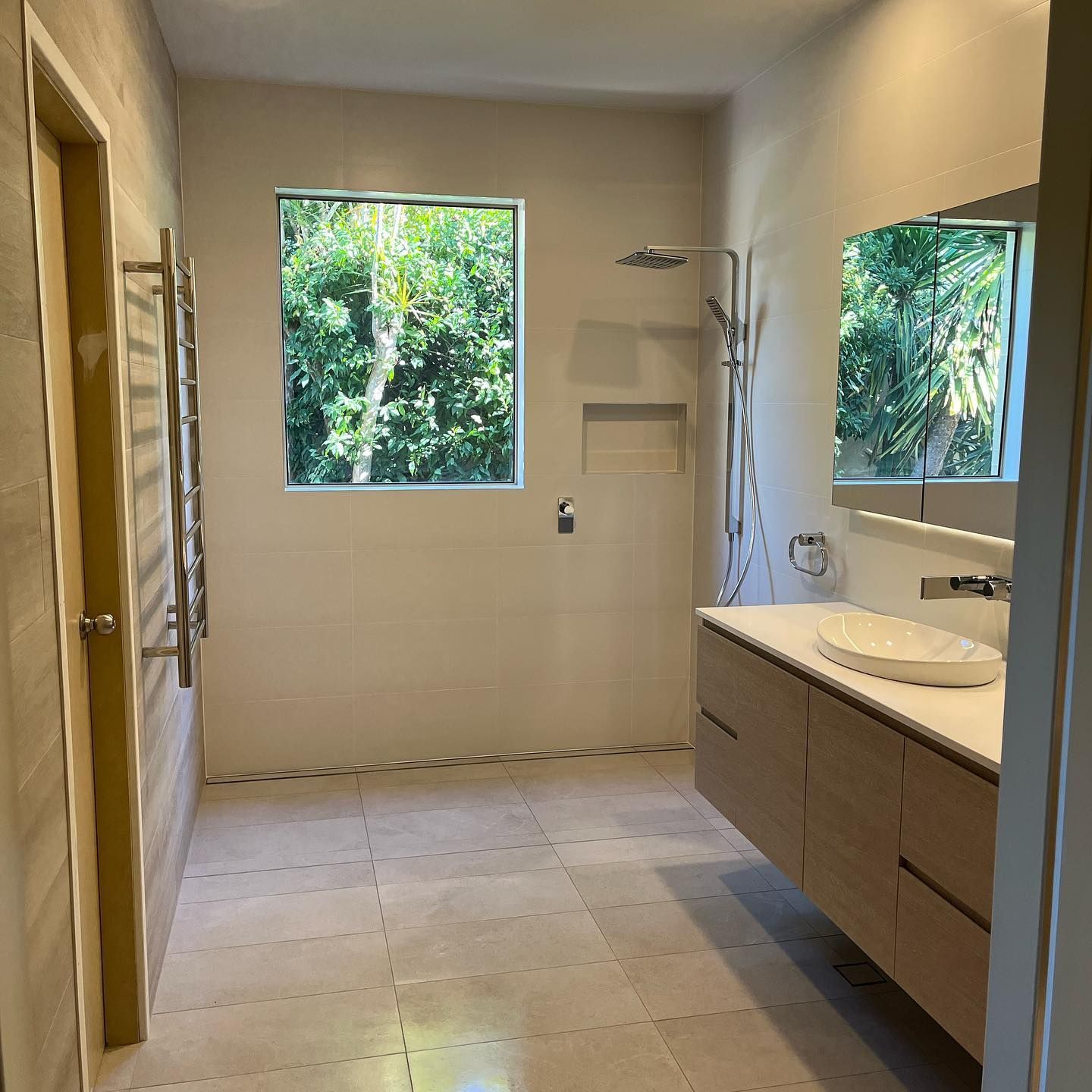 Bathroom With Beige Tiles, Vanity, and Large Window With a Lush Green View — JNR Building And Maintenance in Green Hill, QLD