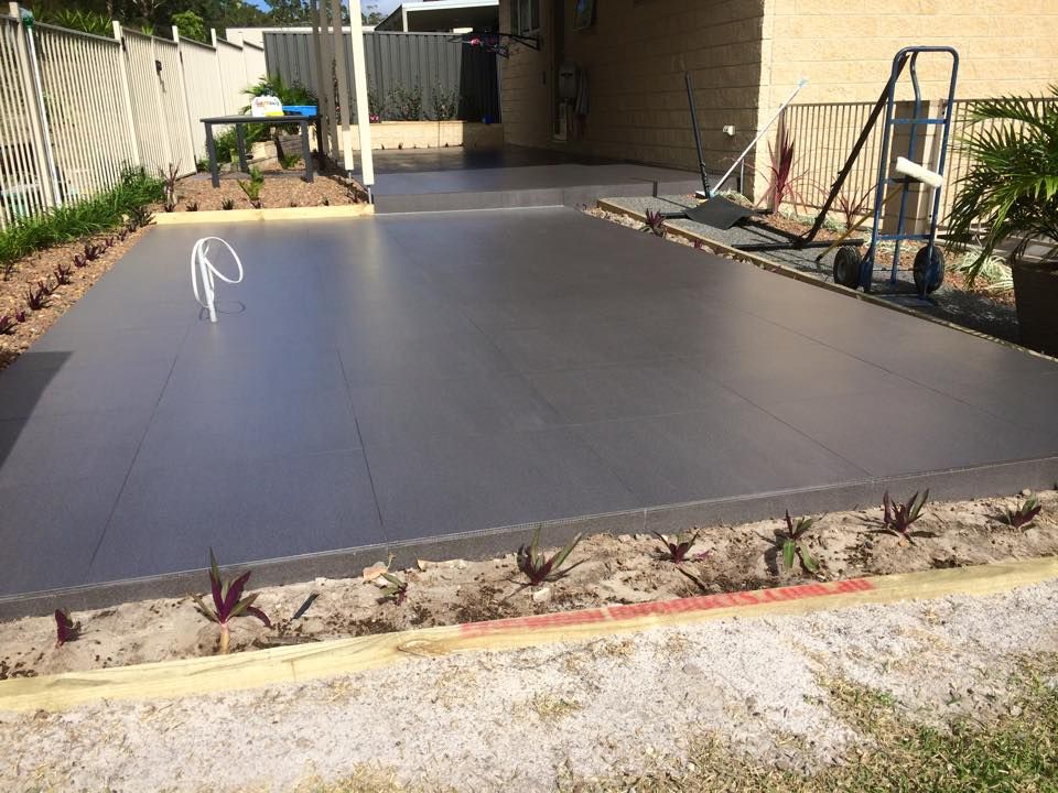 Newly Poured Gray Concrete Patio With Garden Edging — JNR Building And Maintenance in Green Hill, QLD