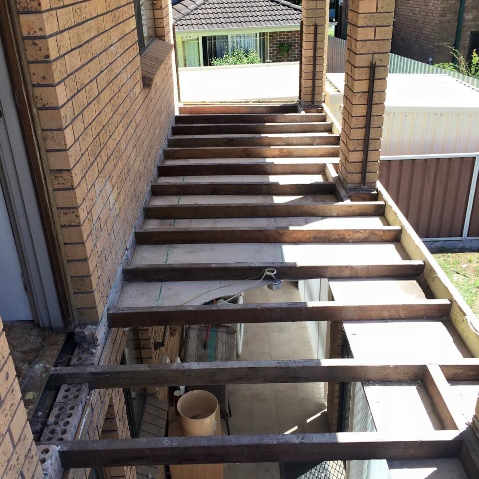 Wooden Staircase Under Construction With Brick Walls — JNR Building And Maintenance in Green Hill, QLD
