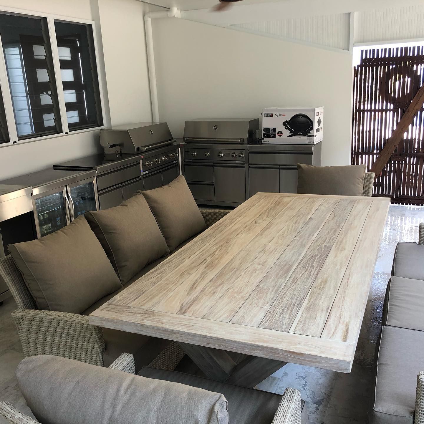 Outdoor Dining Area With Grill and Large Wooden Table — JNR Building And Maintenance in Green Hill, QLD