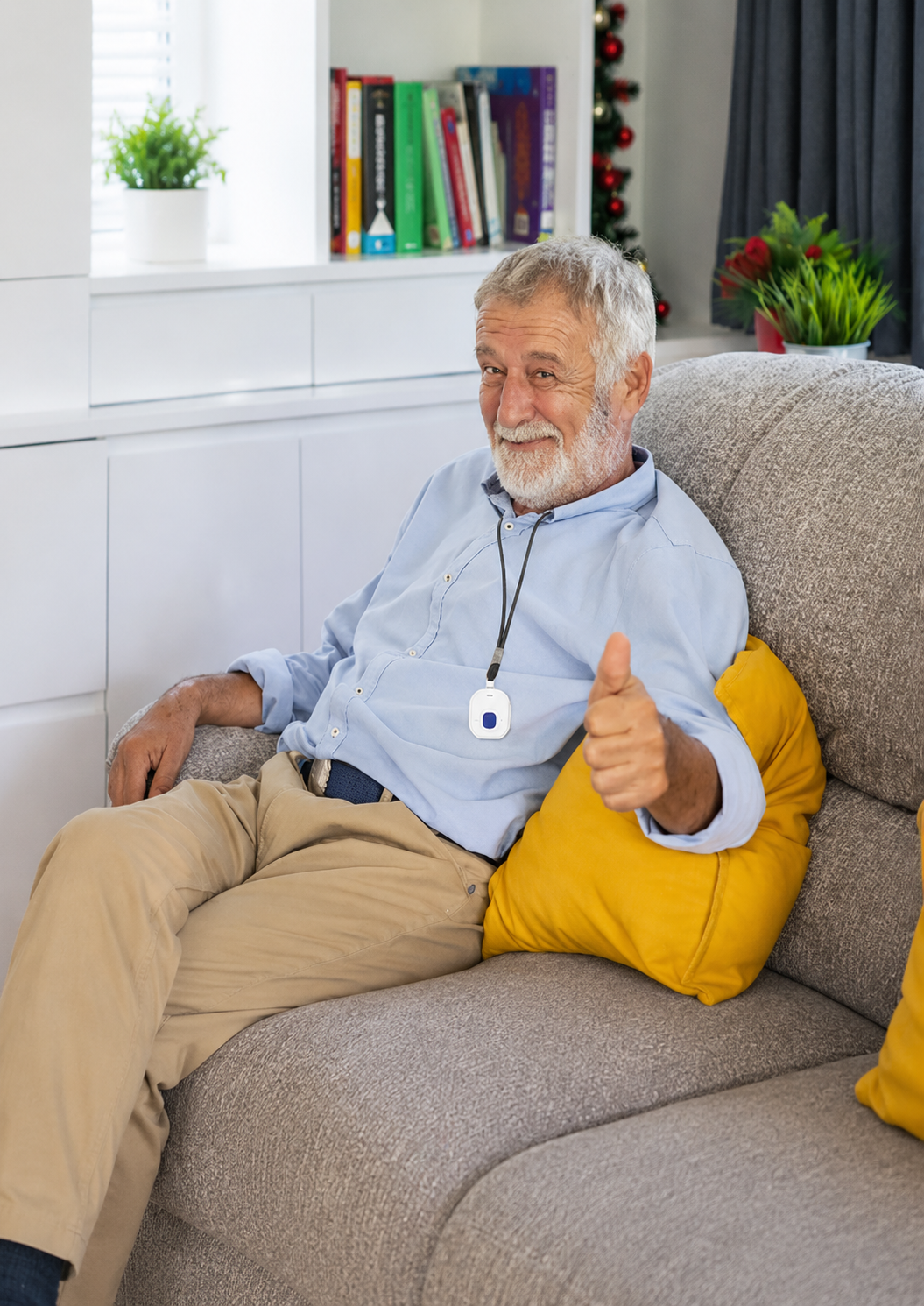 Smiling man relaxing on a gray sofa with yellow pillows in a bright living room