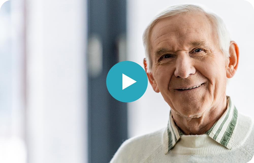 An elderly man is smiling for the camera