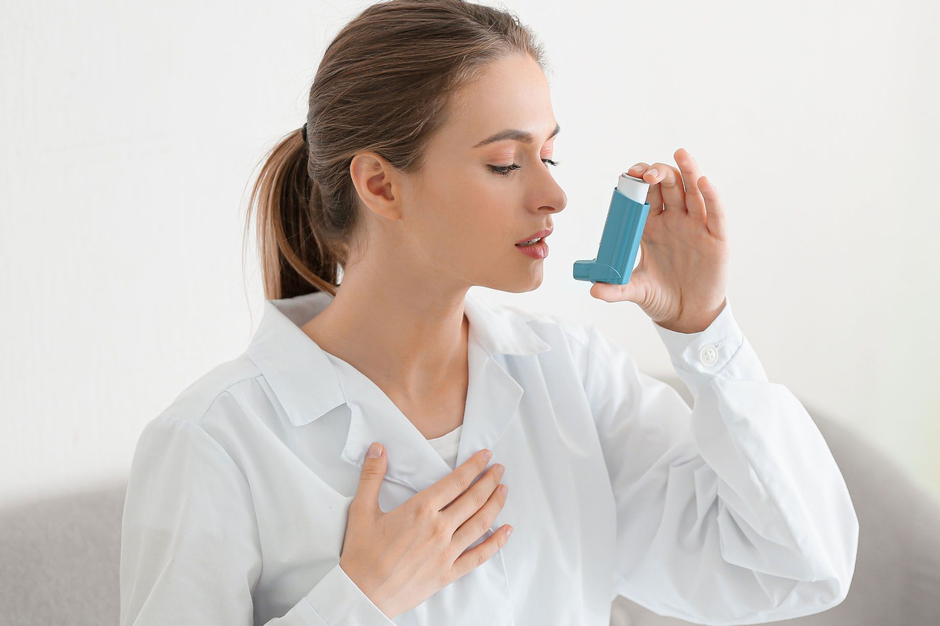 Woman with inhaler having asthma attack