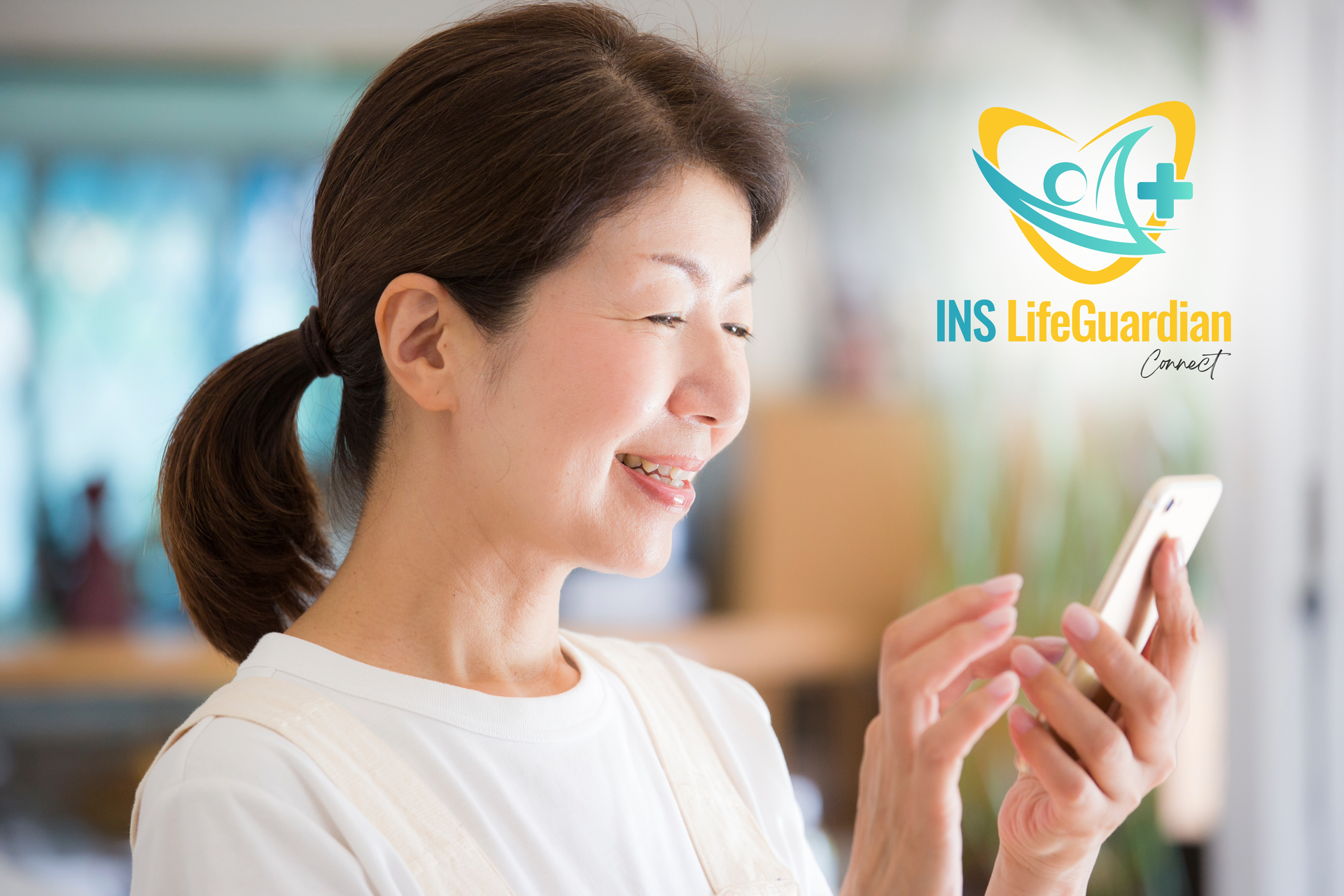 A woman is smiling while looking at her cell phone.
