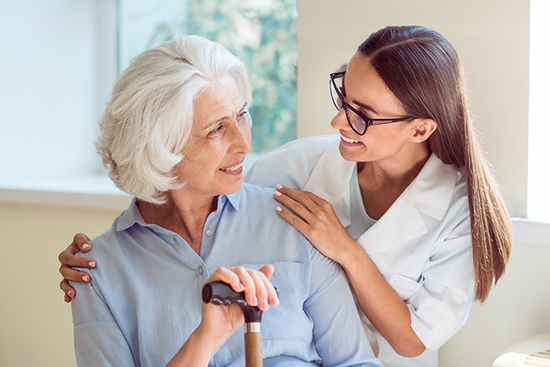 a female carer reassuring an elderly woman