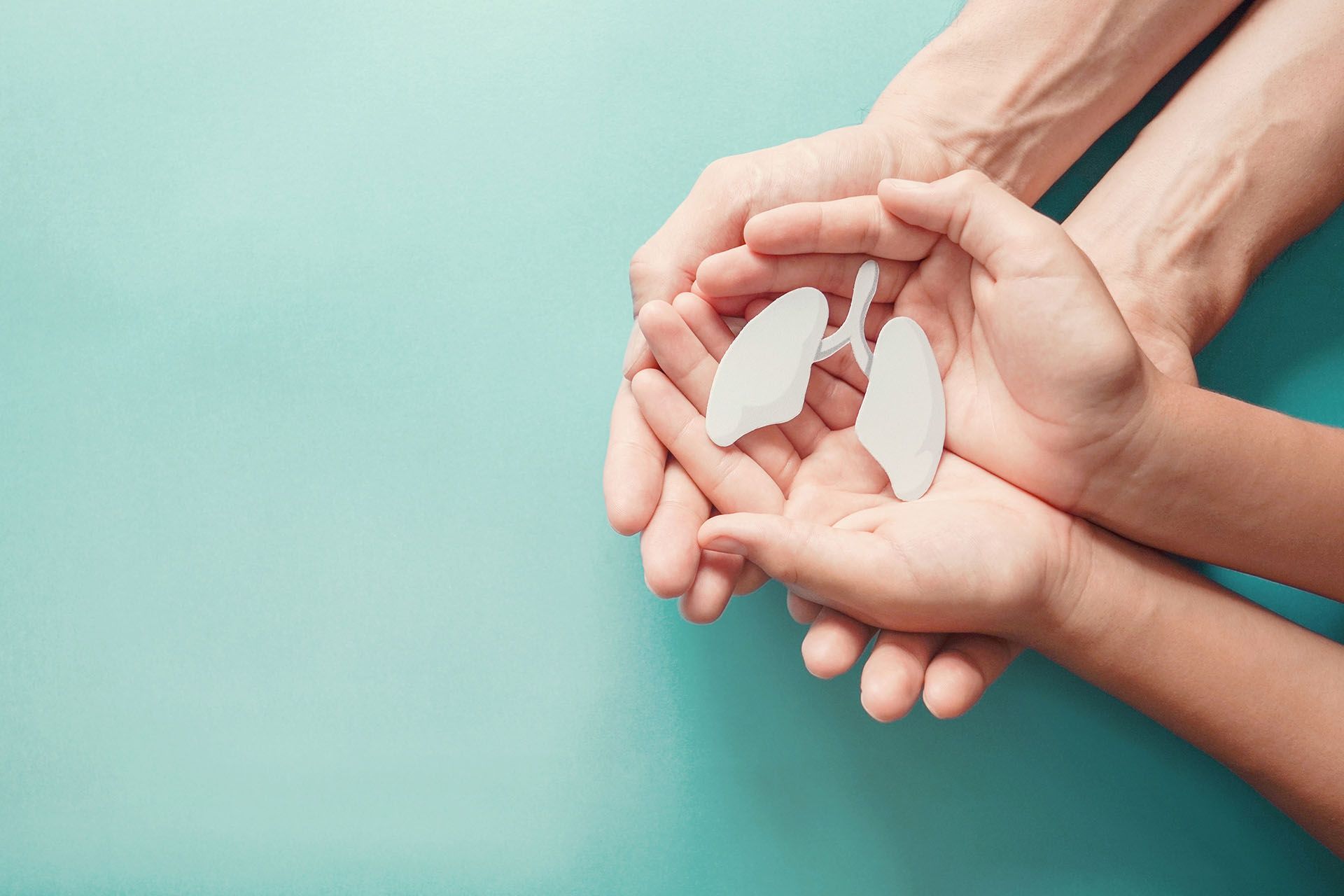 A person and a child are holding lungs in their hands, visual representing COPD.