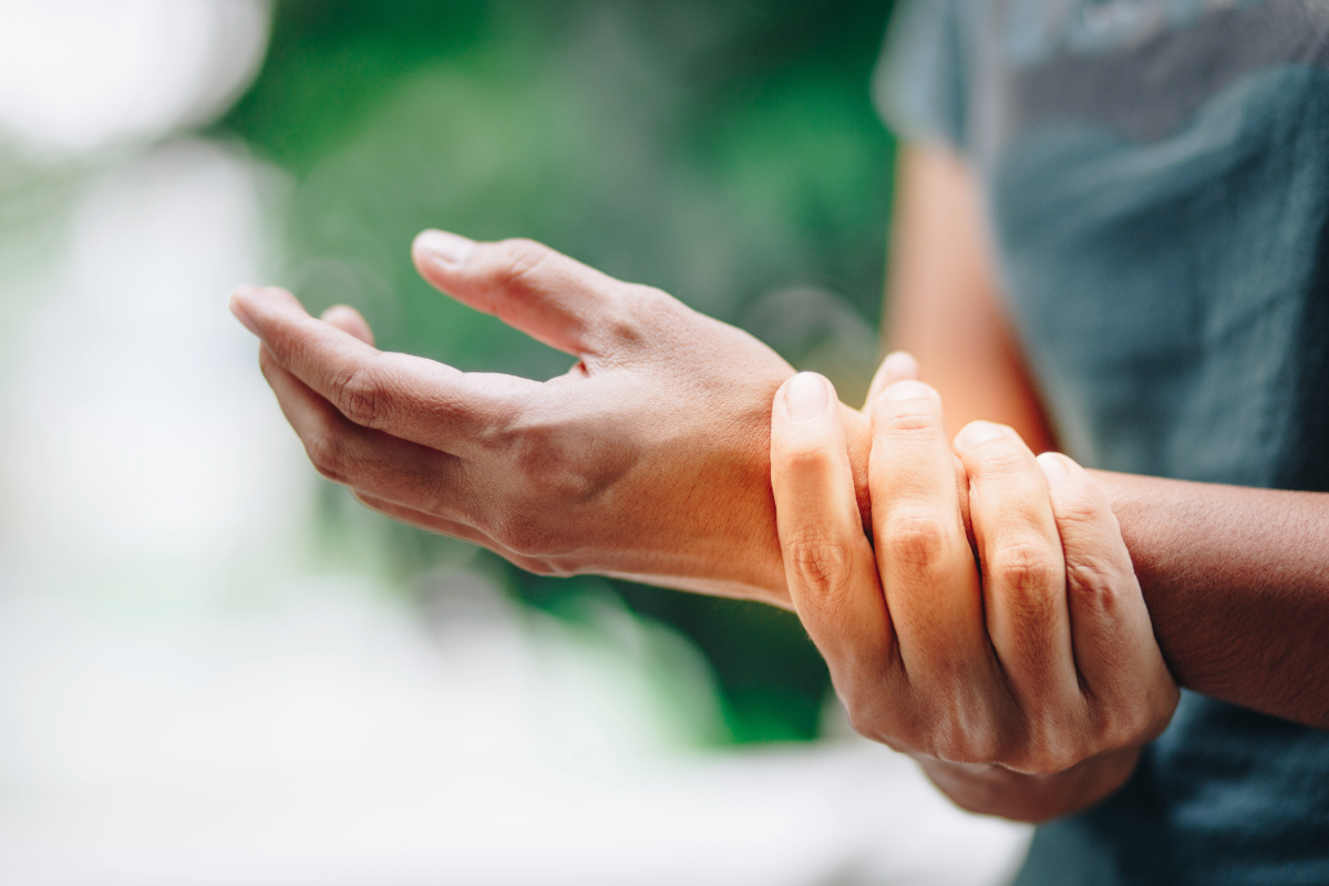 Hand holding wrist in a close-up, suggesting pain or injury
